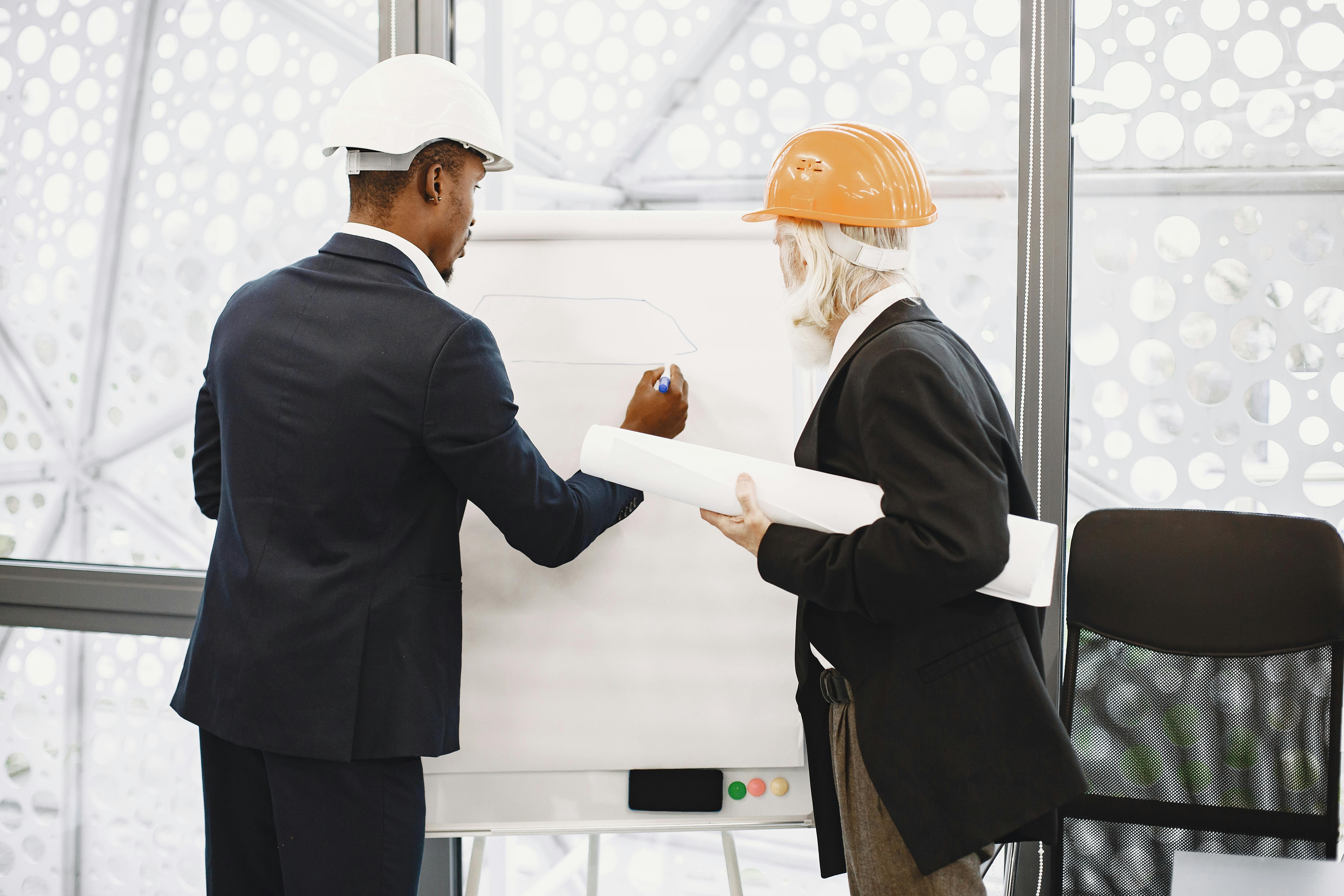 Two engineers drawing a plan of action.